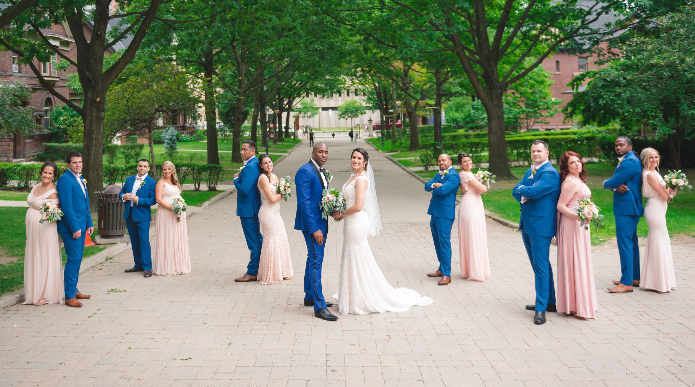 Newlyweds surrounded by their wedding party outdoors